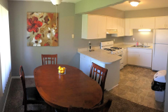 apartment with white kitchen and dining room with brown wooden dining table